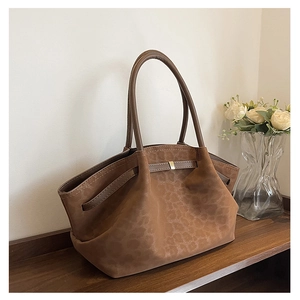 Détail du sac cabas en daim marron avec motif léopard subtil et boucle dorée élégante