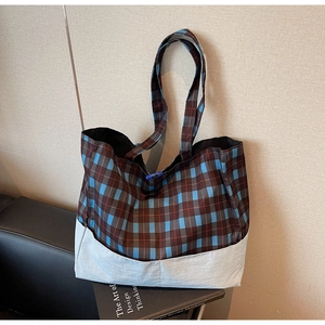 Détail du motif à carreaux bleu et marron et de la base renforcée d'un grand sac cabas