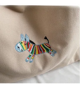 Macro shot of colorful zebra embroidery detail on high-quality beige canvas tote bag