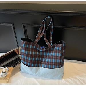 Détail du grand sac cabas à carreaux avec bouton bleu et base de couleur contrastée