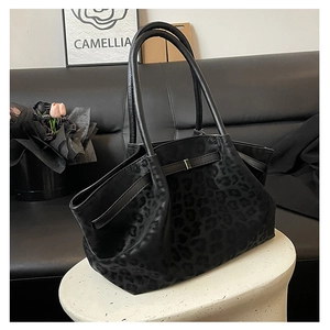 Détail d'un grand sac cabas noir avec texture léopard et boucle métallique élégante