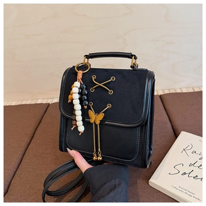 Detailed shot of black vintage handbag with butterfly buckle and colorful beaded charm