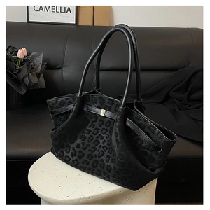 Vue détaillée du cabas noir à motif léopard avec texture en fausse fourrure et anses en cuir