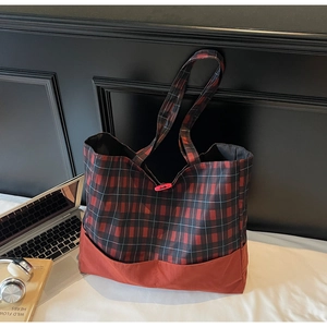 Détail du grand sac cabas à carreaux rouges avec ordinateur et casque de bureau