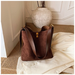 Detail of coffee brown suede tote bag featuring premium leather straps and golden lock