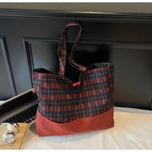 Détail d'un grand sac cabas à carreaux rouges avec fermeture à bouton rouge vif chic