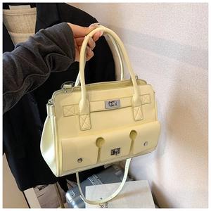 Détail d'un sac à main jaune clair avec fermoir rotatif argenté et surpiqûres élégantes