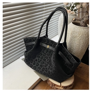 Detail of black leopard print tote bag with gold metal buckle and textured suede fabric