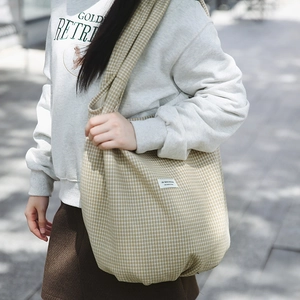 Dettaglio della tracolla larga e del tessuto in nylon a scacchi della grande borsa tote