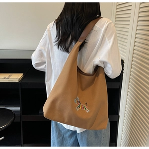 Brown tote bag detail featuring colorful zebra embroidery and durable shoulder strap