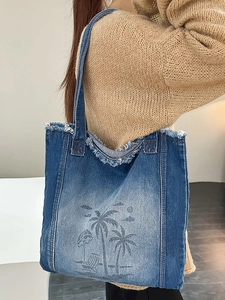 Blue gradient denim tote bag with palm tree print and frayed edges on shoulder