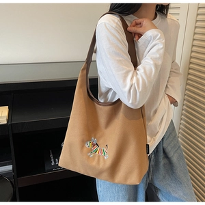 Detail of embroidered zebra pattern and premium leather trim on canvas tote bag