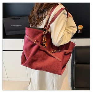 Detail of burgundy suede tote bag with decorative vintage beads and shoulder strap