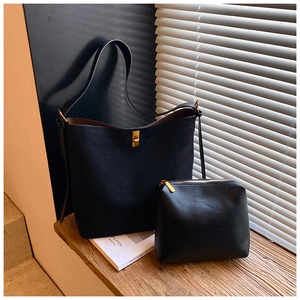 Detail of black suede tote bag with gold twist lock and matching small zippered pouch