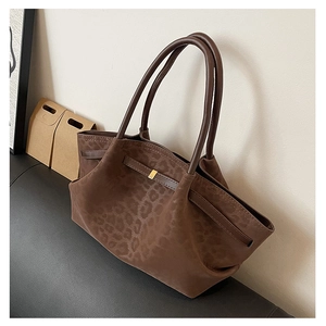 Détail de la texture léopard et boucle en métal doré sur un sac cabas marron rétro