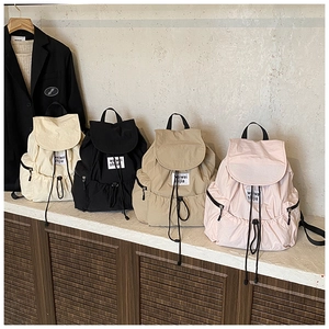 Row of four colorful nylon backpacks with drawstring closure and front flap details