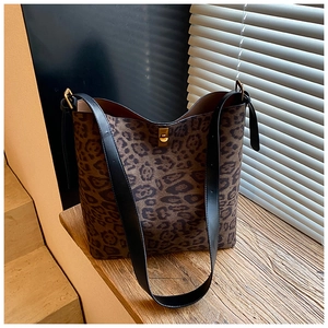 Detailed view of the leopard print bucket bag featuring a gold twist lock and black strap
