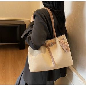 Detail of the vintage suede tote bag with a decorative brown strap and cute bear charm