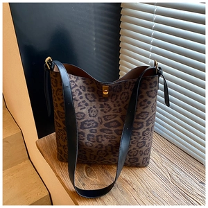 Detail of leopard print bucket bag featuring black leather strap and gold buckle closure