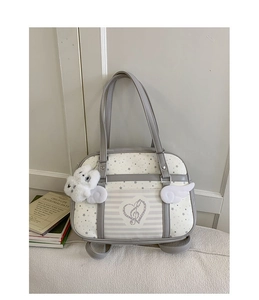 Detail view of stylish tote bag featuring plush wings and heart embroidery