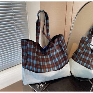 Détail du sac cabas à carreaux bleu et marron avec coutures contrastées et nylon