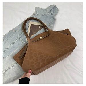 Gros plan du sac vintage marron avec motif léopard, texture daim et boucles en métal