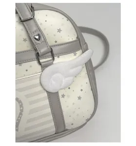 Dettaglio della borsa bianco sporco con stampa a stella grigia e accessorio ala 3D creativo