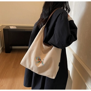 Detailed embroidery of rainbow zebra on beige canvas tote bag with brown leather strap