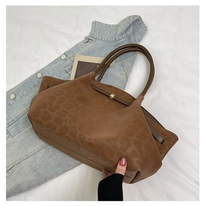 Gros plan sur la texture léopard et la boucle dorée du sac cabas marron élégant