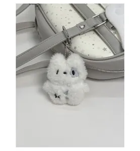 Dettaglio di un ciondolo in peluche bianco con ricamo a stella su uno zaino casual