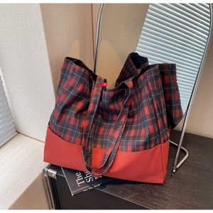 Détail du grand sac cabas à carreaux rouge et noir avec boucle sur table en bois