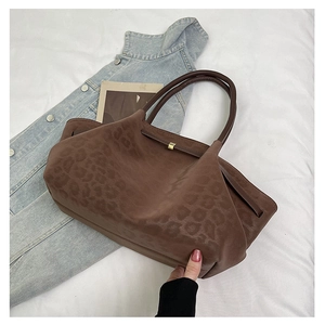 Détail de la texture léopard marron foncé et de la boucle métallique sur le sac cabas