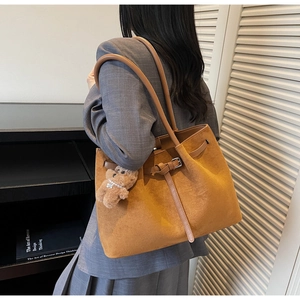 Brown suede oversized tote bag with long leather straps shown on a grey blazer outfit