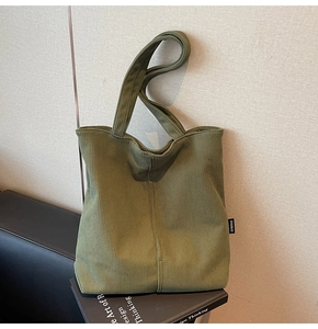 Detail of olive green corduroy tote bag showing fine vertical stripes and side brand tag