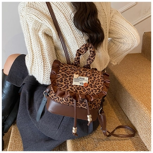 Detail of leopard print mini backpack with brown leather trim and ruffle drawstring
