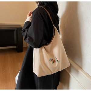Detail of embroidered colorful zebra pattern on beige canvas hobo tote bag