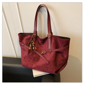 Close-up of burgundy suede tote bag with retro wooden beads and gold hardware details