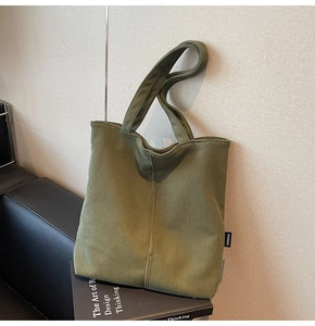 Detail of army green corduroy tote bag showing vertical ribbed texture and side label