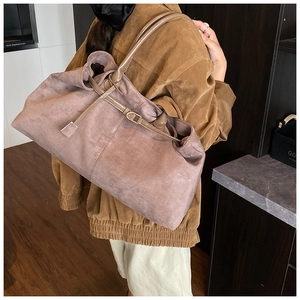 Detail of large dusty pink suede tote bag with brown leather handles on model