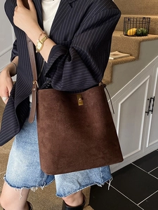 Brown frosted suede bucket bag with gold metal clasp shown on a crossbody model