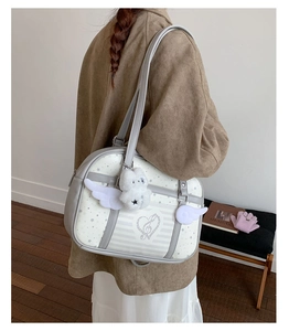 Dettaglio borsa stile JK con ali decorative, stelle e ciondolo a coniglietto