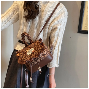 Detail view of mini leopard print backpack with brown ruffles and drawstring closure