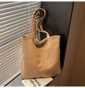 Close-up of khaki corduroy tote bag texture with striped fabric detail by a window