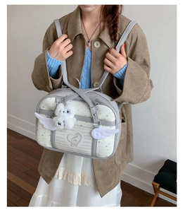 Close-up of JK style shoulder bag with star pattern, white wings and plush rabbit charm