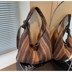 Detail of bohemian striped woven bag featuring ethnic geometric patterns and knot strap