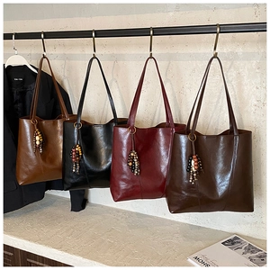 Variety of four glossy vintage tote bags in brown, black, and red with beaded charms