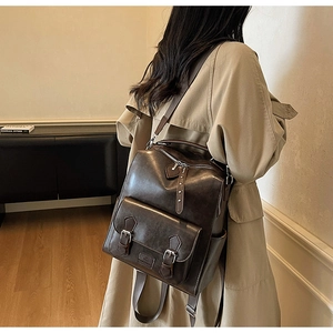 Detail view of dark brown vintage leather backpack with magnetic flap and metal buckle accents