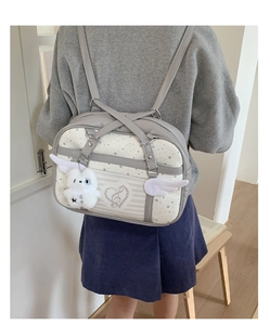 Detail of JK uniform style grey and white bag with wing decor and plush bunny charm