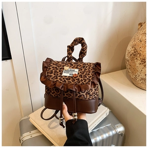 Close-up of leopard print mini backpack with brown satin ruffles and OOMU BRAND label