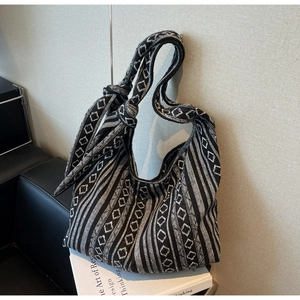 Detailed view of large ethnic pattern tote bag with knot strap on minimal decor background